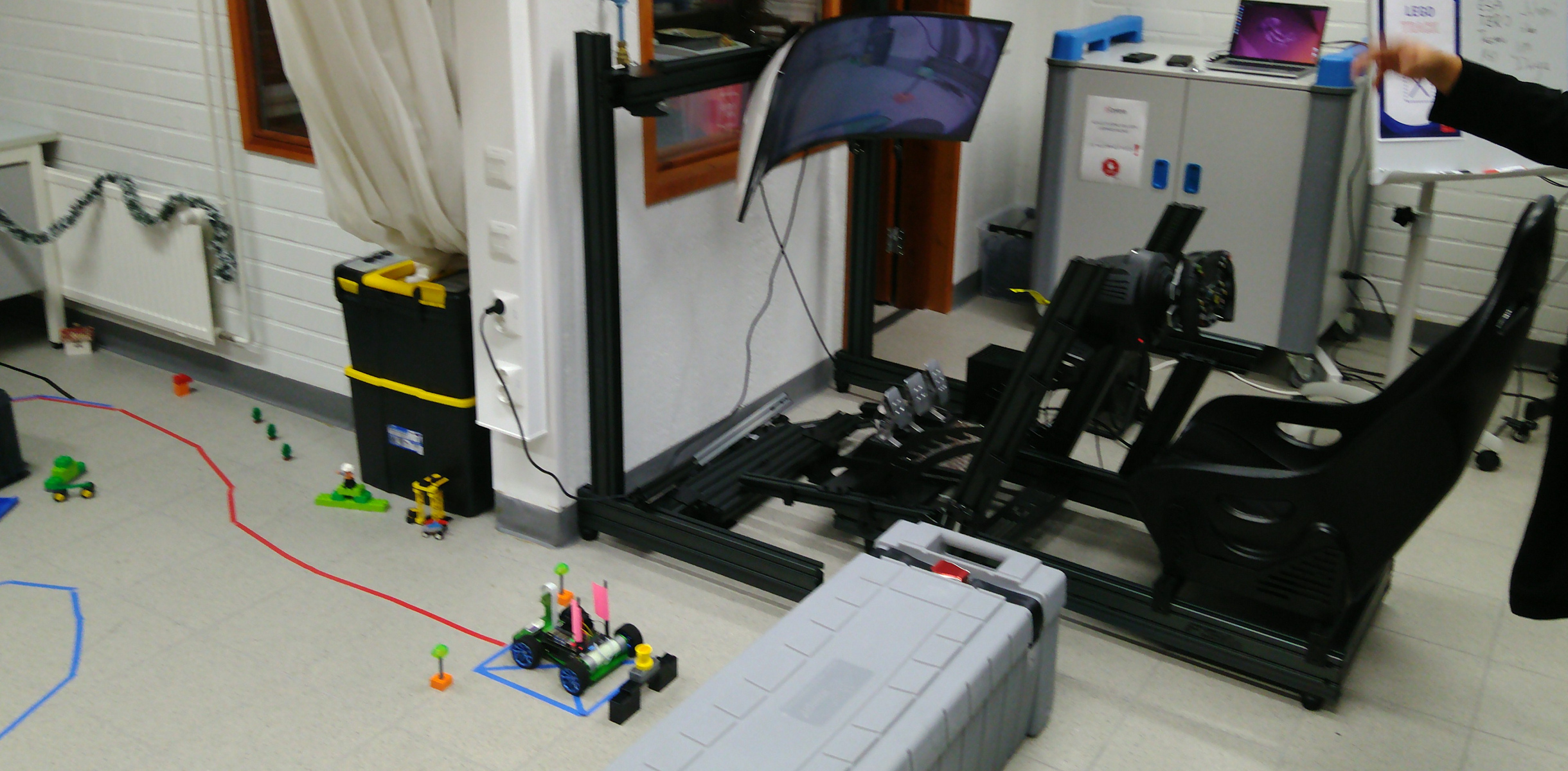 A model car and chair with steering wheel to control it in the makerspace at Centria University Kokkola, Finnland